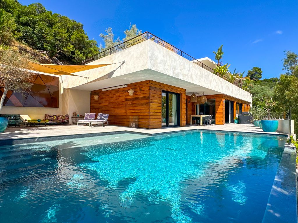 Luxury contemporary villa with infinity pool, modern architecture, and high-end amenities, located in a preserved natural environment on the French Riviera.